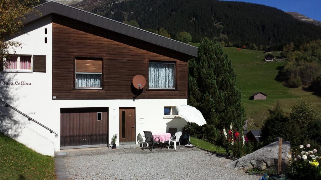 ein Haus mit einem Tisch und Stühlen davor in der Unterkunft Casa Collina in Disentis