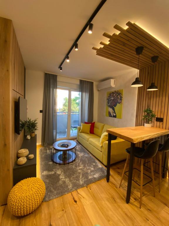 a living room with a yellow couch and a table at Tesla 8 Apartment in Novi Sad