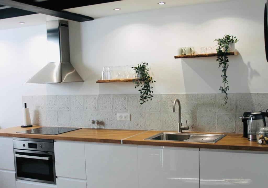 une cuisine avec des armoires blanches et un évier dans l'établissement Duplex atypique rénové en plein centre du village, à Cassis