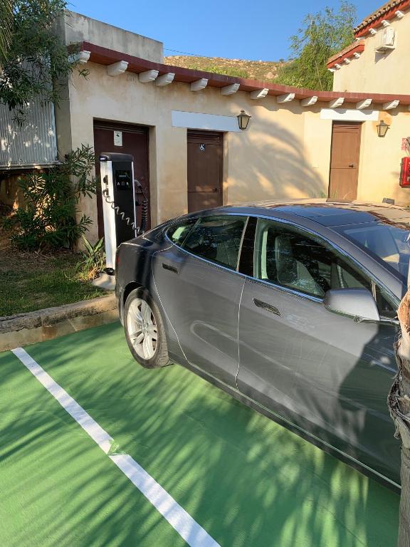a car parked in a parking lot in front of a house at Dulce Nombre Hotel - Apartamentos in Tarifa