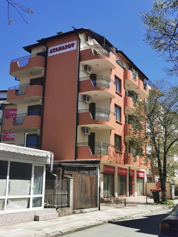 a tall pink building with a sign on the side of it at Hotel Atanasov 1 in Primorsko