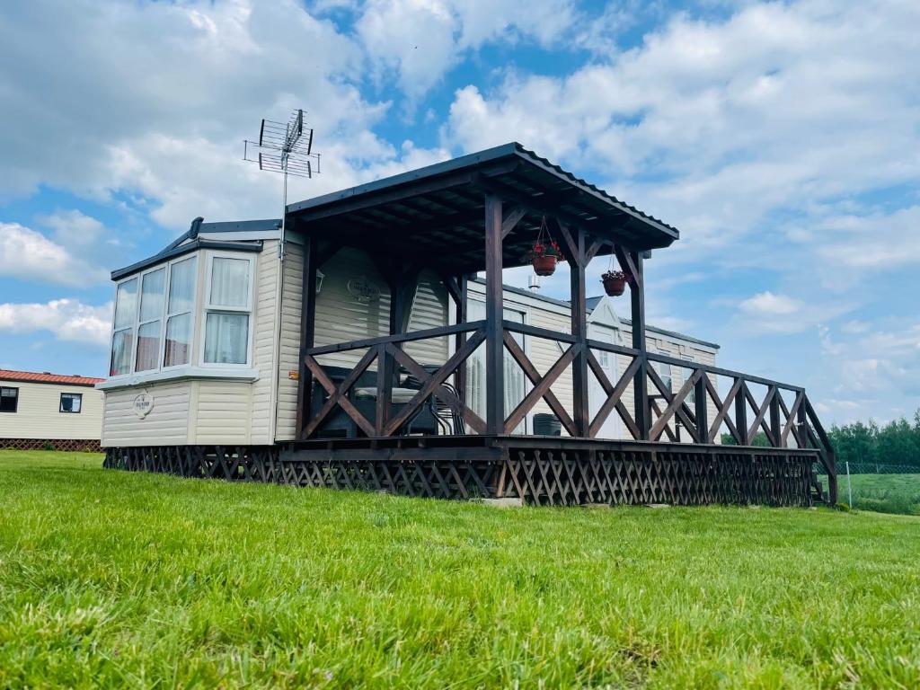 ein Haus auf einem Grasfeld in der Unterkunft Domek na Skraju Lasu Kruklanki koło Giżycko Mazury in Kruklanki
