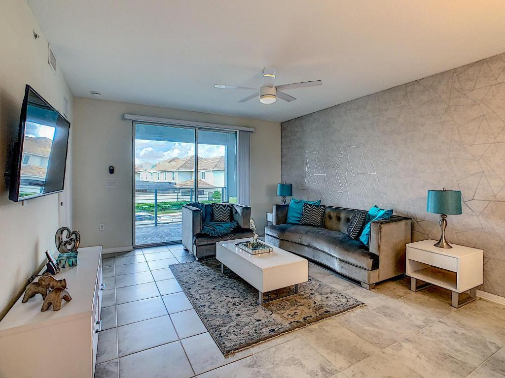 ein Wohnzimmer mit Sofa und Tisch in der Unterkunft Luxury Brand NEW 2 bedroom apt near DISNEY! in Kissimmee
