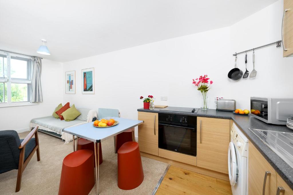 a kitchen and living room with a table and a couch at Central Hackney Apartment in London