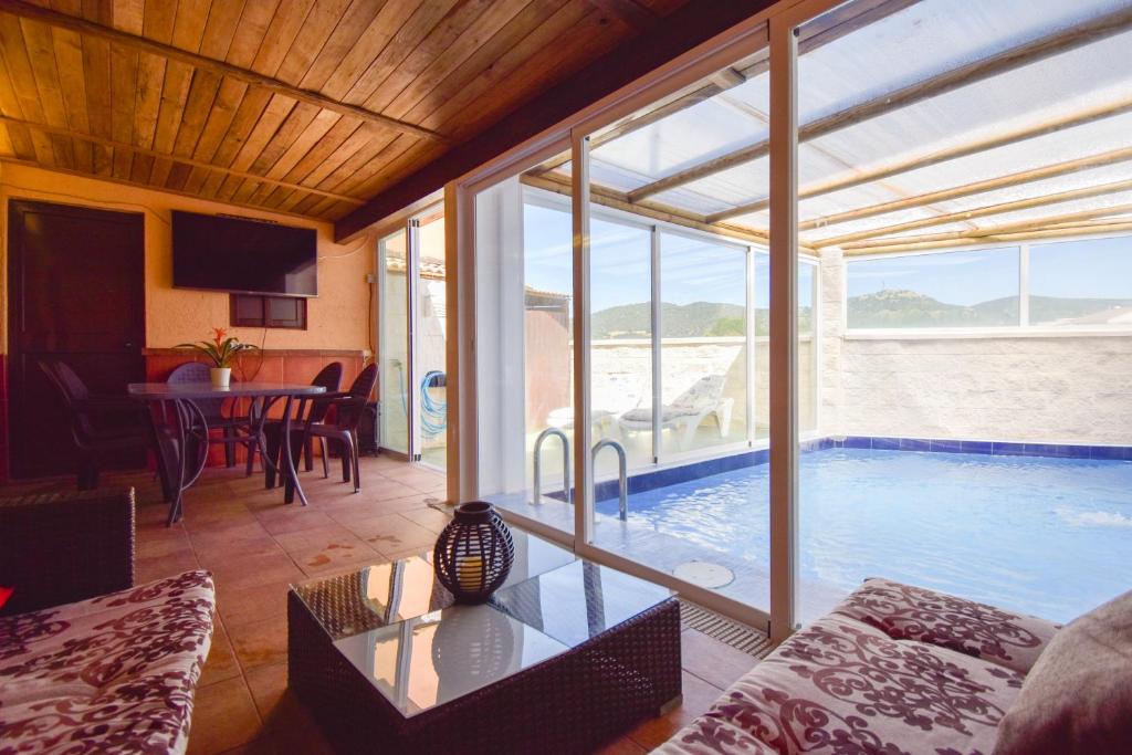 a living room with a swimming pool and a table at VILLA ELISABETH Piscina y Terraza con Aire Acondicionado in Arriate