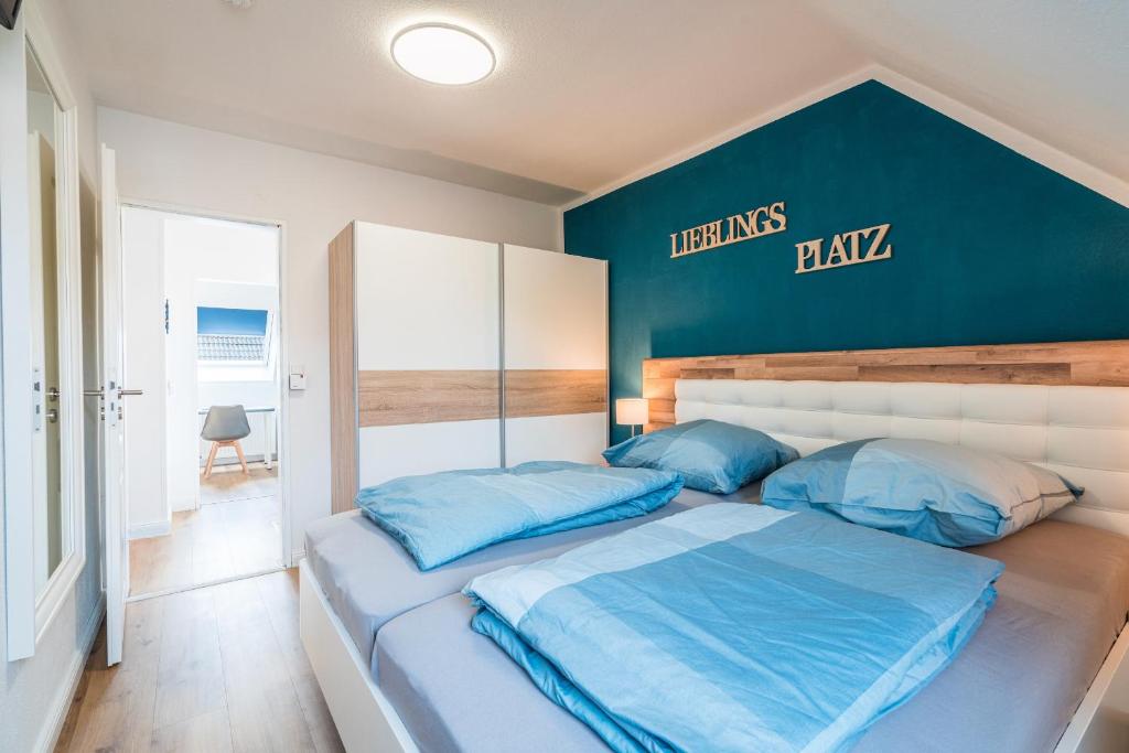 um quarto com uma cama com almofadas azuis em Ferienhaus Steuerbord mit Kamin und Terrasse - 4 Sterne DTV-Klassifizierung em Carolinensiel
