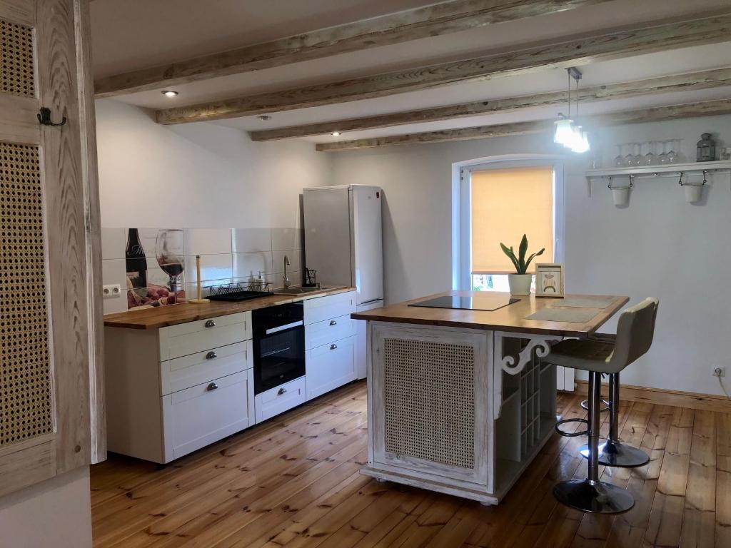 a kitchen with white cabinets and a table in it at Mazurski Dom in Pisz