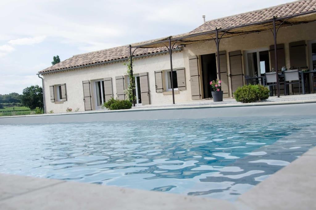 una casa con piscina frente a un edificio en Villa climatisée avec piscine CHAUFFÉE au cœur du massif d'Uchaux , calme absolu !, en Mondragon