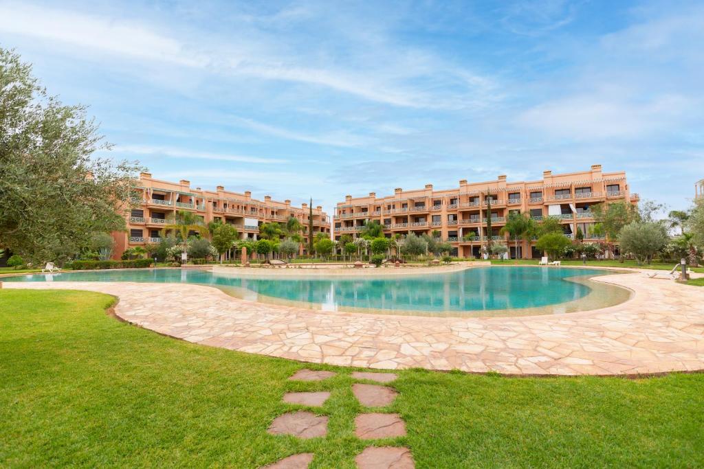 une grande piscine en face de deux immeubles d'appartements dans l'établissement Hidden Gem with Self Check-in - Pool & Gym - M6 BLVD, à Marrakech