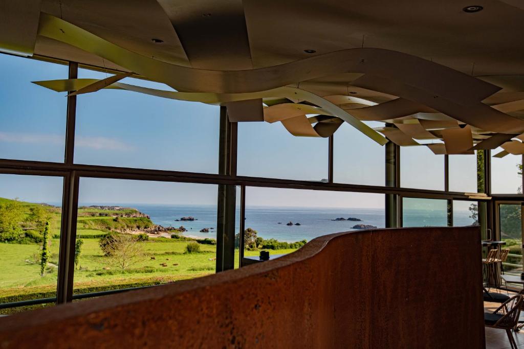 Habitación con ventanas y vistas al océano. en Hotel La Portilla en Niembro