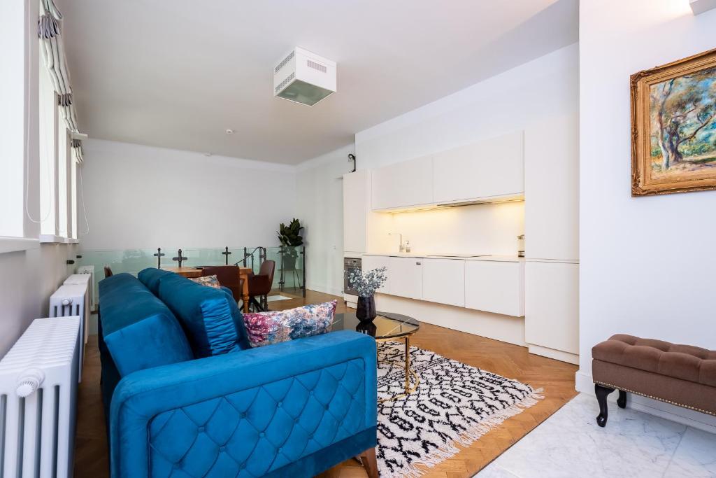 a living room with a blue couch and a table at Pagari Residence in Tallinn