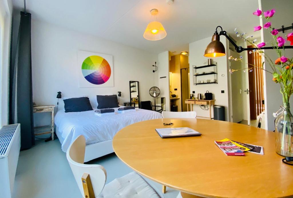 a bedroom with a bed and a wooden table with a desk at Private studio, patio garden and free car parking in Amsterdam