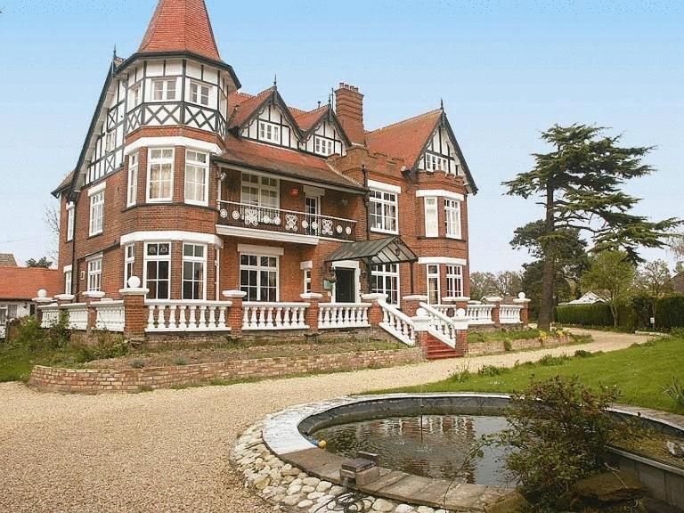 a large house with a pond in front of it at The Grange Hotel in Kings Lynn