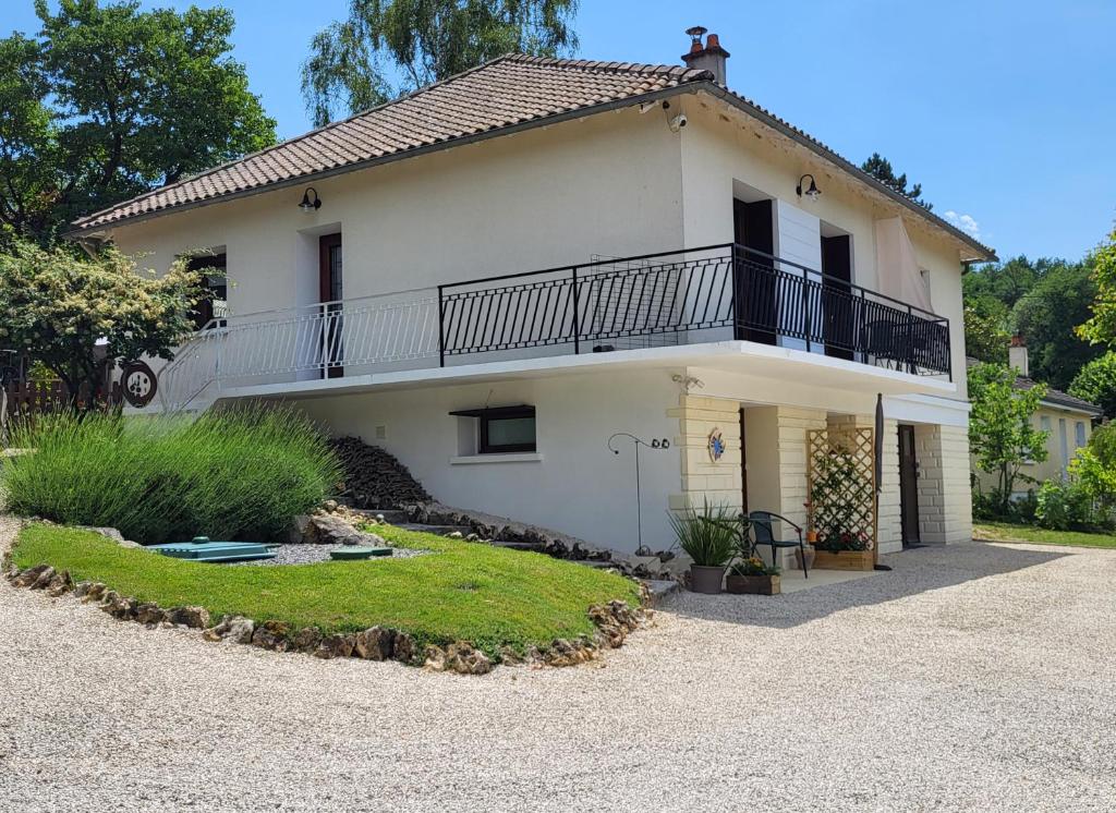 a white house with a balcony and a yard at Le Pré Pigeon 86250 Charroux Vienne in Charroux