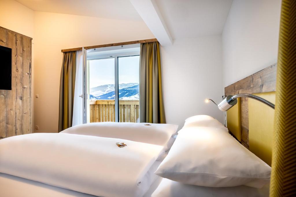 two beds in a room with a view of a mountain at Der Alpenblick in Sankt Johann im Pongau