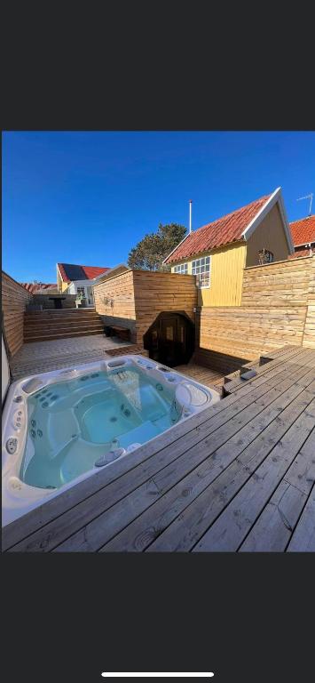 bañera de hidromasaje en la parte superior de una terraza de madera en luksus spahus i skagen, en Skagen