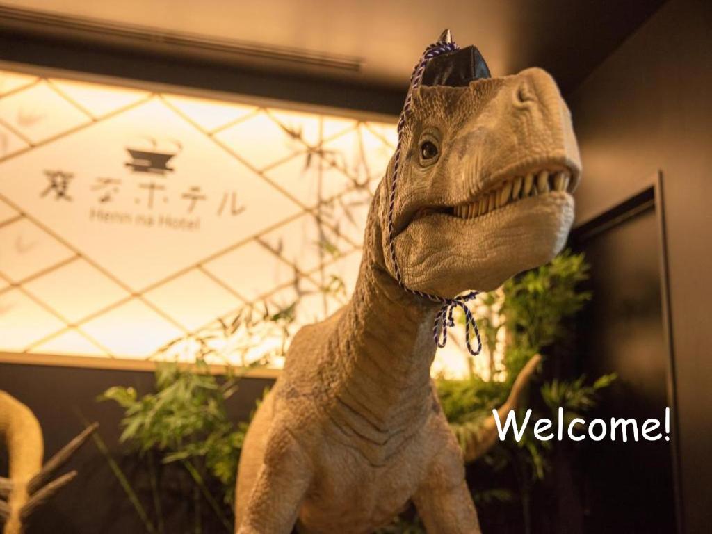 Ein Dinosaurier-Spielzeug steht neben einem Willkommensschild in der Unterkunft Henn na Hotel Tokyo Nishikasai in Tokio