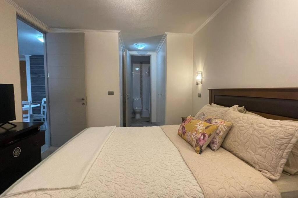 a bedroom with a large bed with two pillows at Hermoso departamento en la Península en Iquique in Iquique