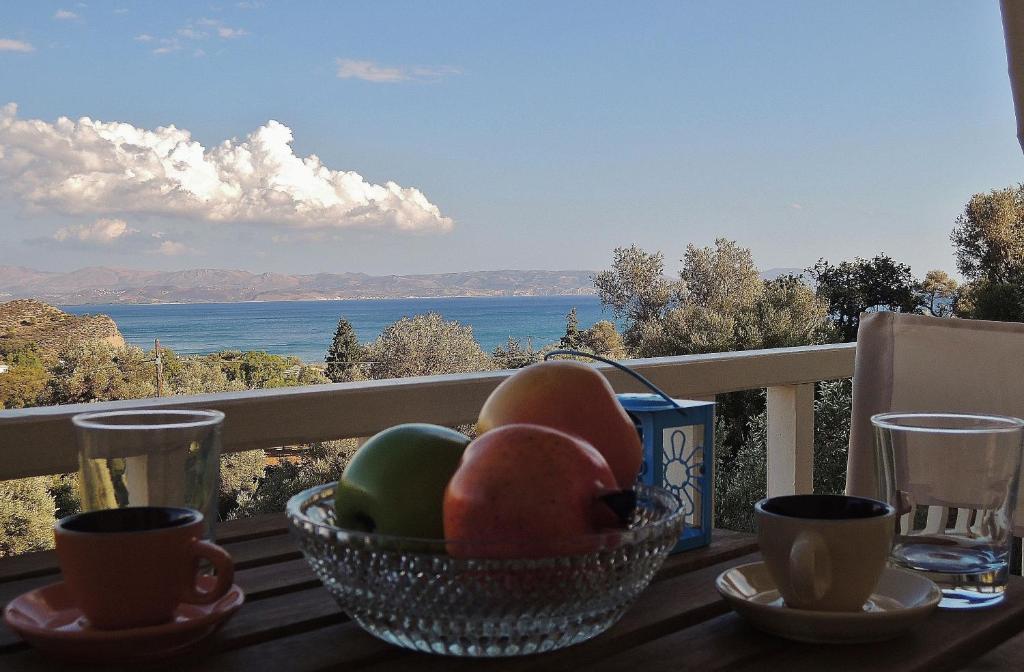 a bowl of fruit on a table with a view of the ocean at Kalliroe Apartments -Creta in Agia Galini