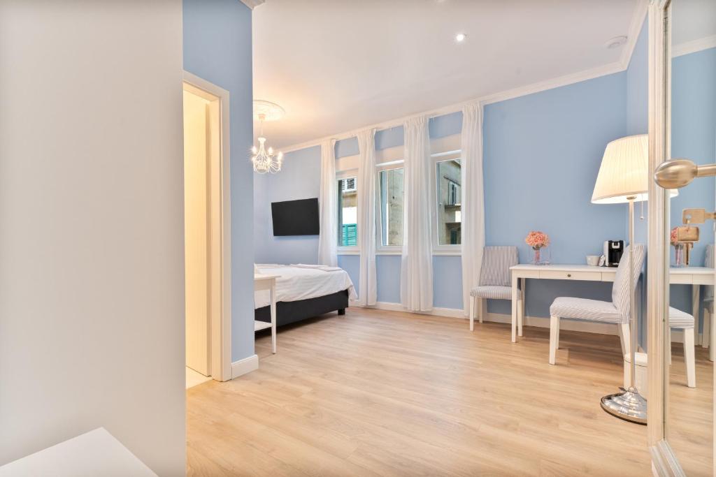 スプリトにあるFinest rooms Leonildaのベッドルーム1室(ベッド1台、デスク、テーブル付)