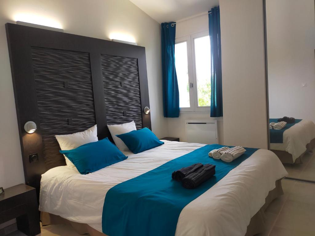 a bedroom with a large bed with blue pillows at VILLA CAREMEAU 2 in Nîmes
