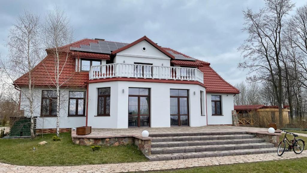 ein weißes Haus mit rotem Dach in der Unterkunft Stanica Rowerowa Wygnanki in Wygnanki
