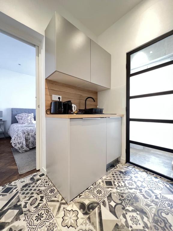 une cuisine avec des placards blancs et une porte menant à une chambre. dans l'établissement LOENA CANNES CENTRE - Appartement rénové 2 pièces - 4 personnes - proche croisette palais festival plage - internet gratuit - climatisation - non fumeur, à Cannes