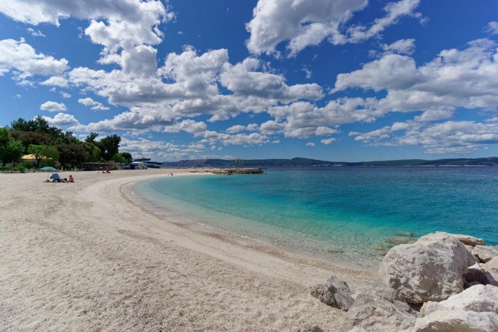 a beach with blue water and clouds in the sky at Kotor in Crikvenica