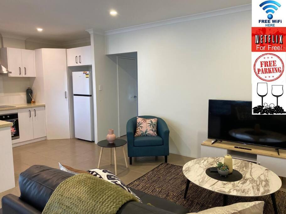 - un salon avec un canapé et une table dans l'établissement Stylish Modern Airport City WIFI Park Netflix Wine, à Perth