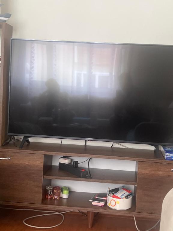 uma grande televisão de ecrã plano num suporte de madeira em Welcome 1 em Istambul