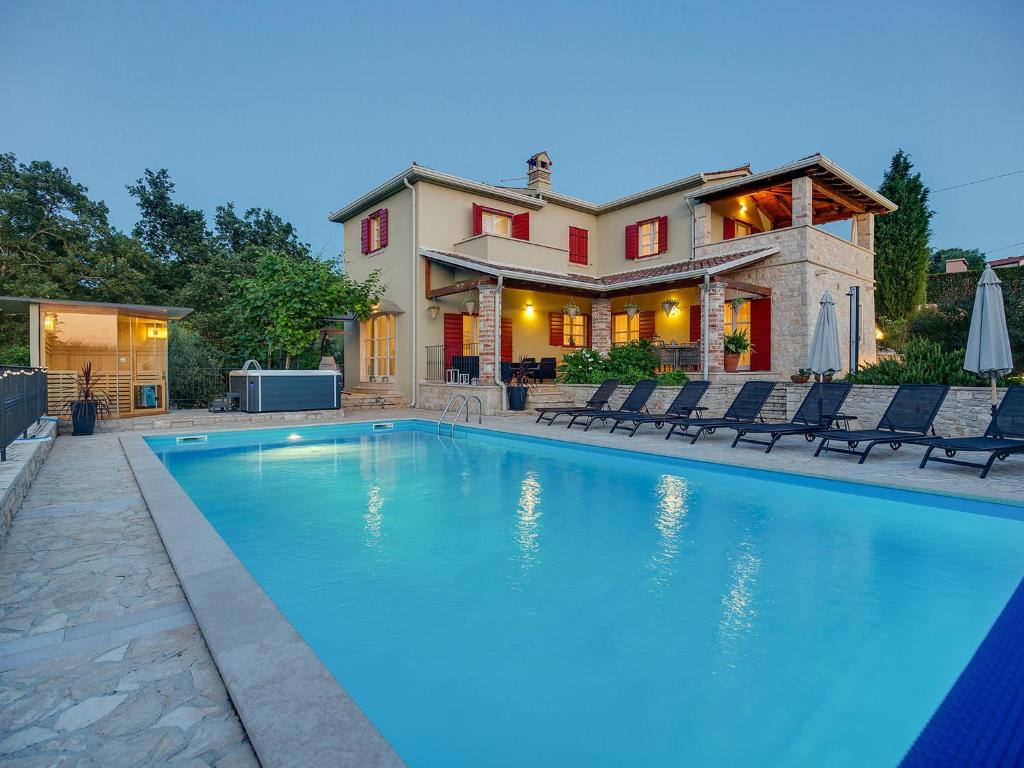 a large swimming pool in front of a house at Villa Stupenda in Montižana