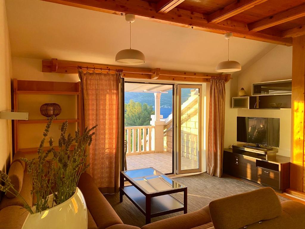 a living room with a couch and a table and a balcony at Apartmani Luka in Korčula