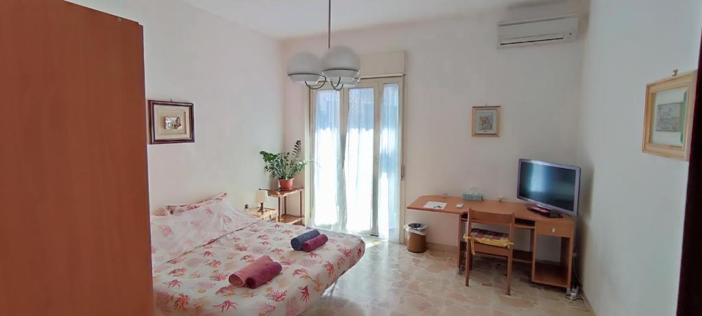 - une chambre avec un lit, un bureau et une télévision dans l'établissement At Claudio and Inna's Home, à Catane