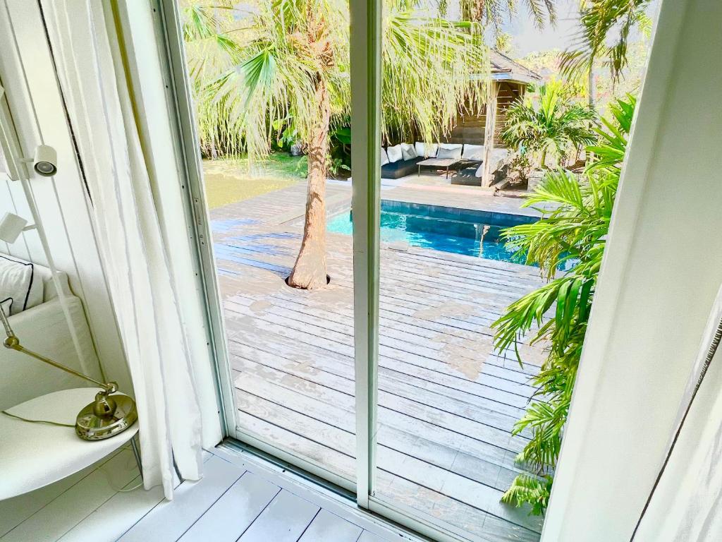 a sliding glass door with a view of a swimming pool at Nice 2 bed-rooms villa at Saint Barth in Saint Barthelemy