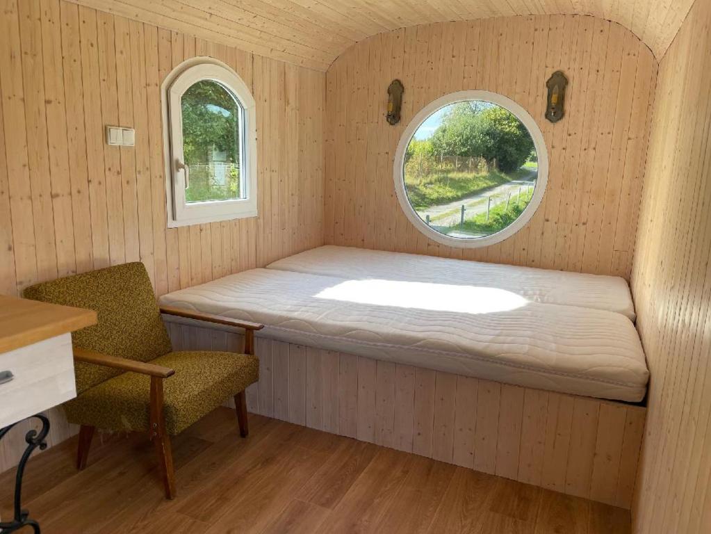 a small room with a bed and a window at Glamping MARINGOTKA - malebný ladův kraj in Stříbrná Skalice