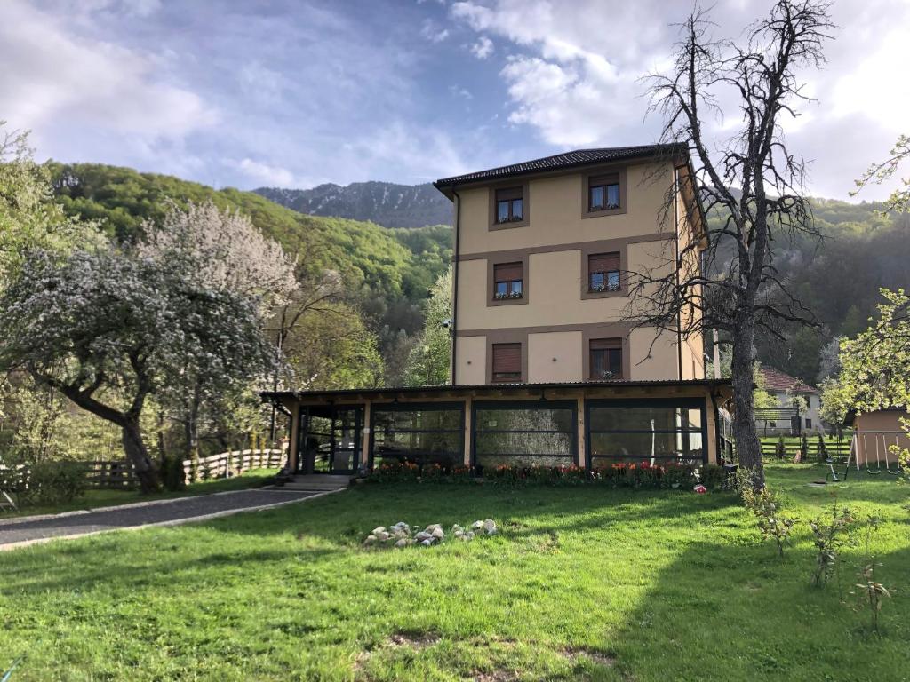una casa grande en medio de un campo verde en Zvjezdana dolina Garni hotel en Andrijevica