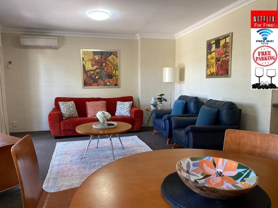 a living room with red and blue couches and a table at SUBI CENTRAL CLOSE CBD HOSPITALS WIFI NETFLIX WINE in Perth