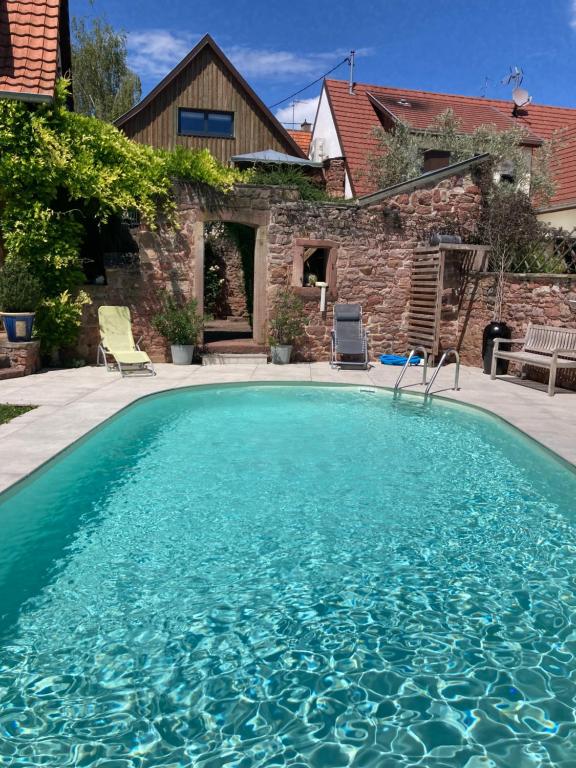 une piscine devant une maison dans l'établissement Le Grenier - Piscine et SPA, à Marlenheim