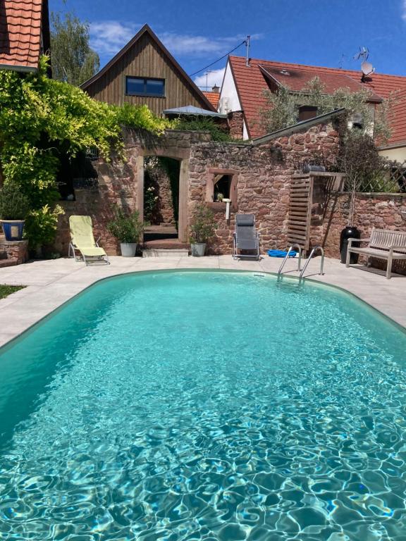 a swimming pool in front of a house at Le Grenier in Marlenheim