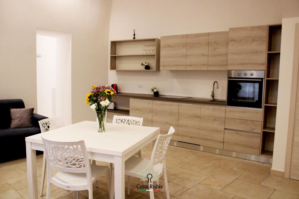 una cucina e un tavolo da pranzo bianco con sedie. di Casa degli Amici a Ruvo di Puglia