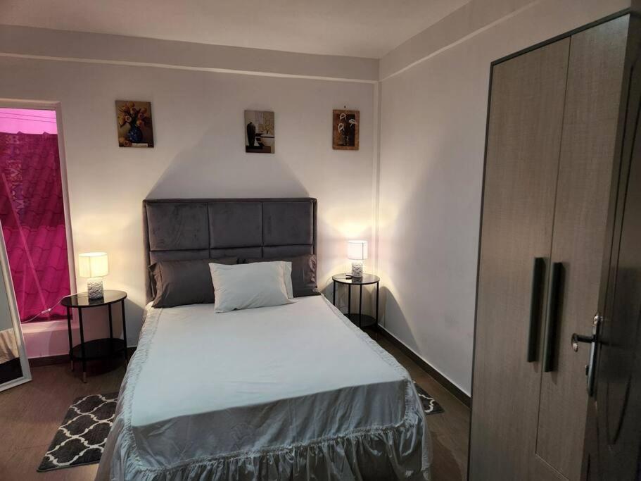 sypialnia z dużym łóżkiem i 2 lampami w obiekcie 28A, Apt#13 Lumir Apartamentos. Encantador Parque Incl. w mieście Luanda