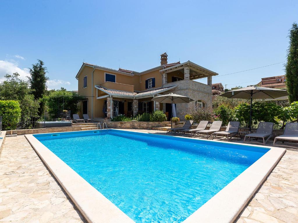 a swimming pool in front of a house at Villa Salvea with heated pool in Montižana