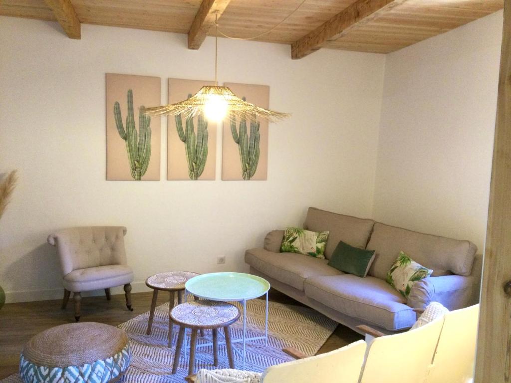 a living room with a couch and a table at La Bohème. Maison de village cosy, jardin et spa. in Octon