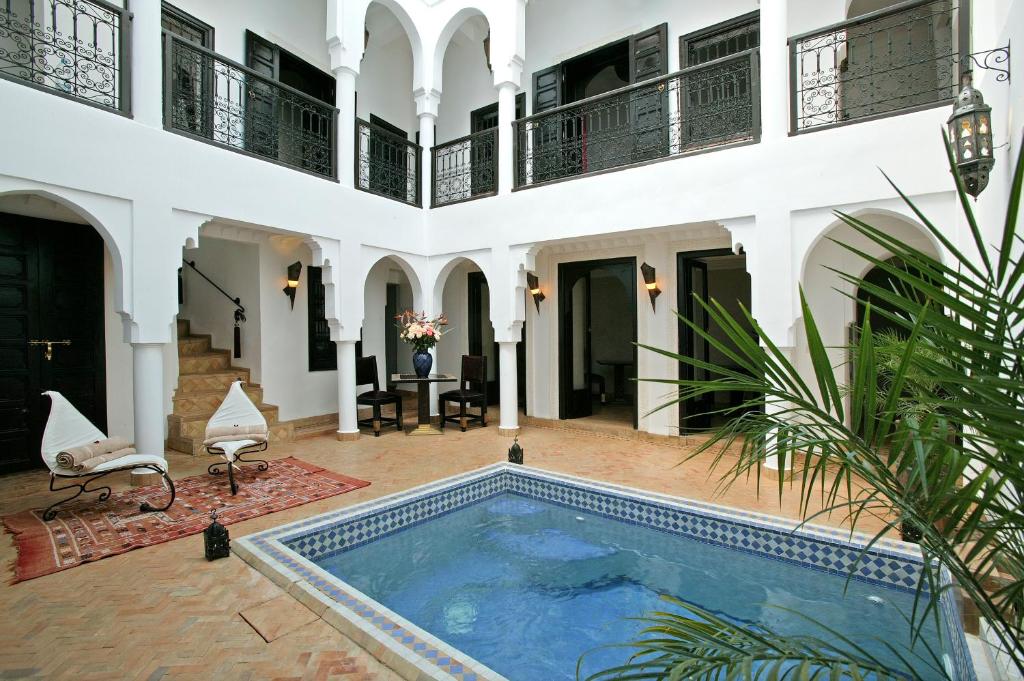 a courtyard with a swimming pool in a house at Riad Baba Ali in Marrakesh