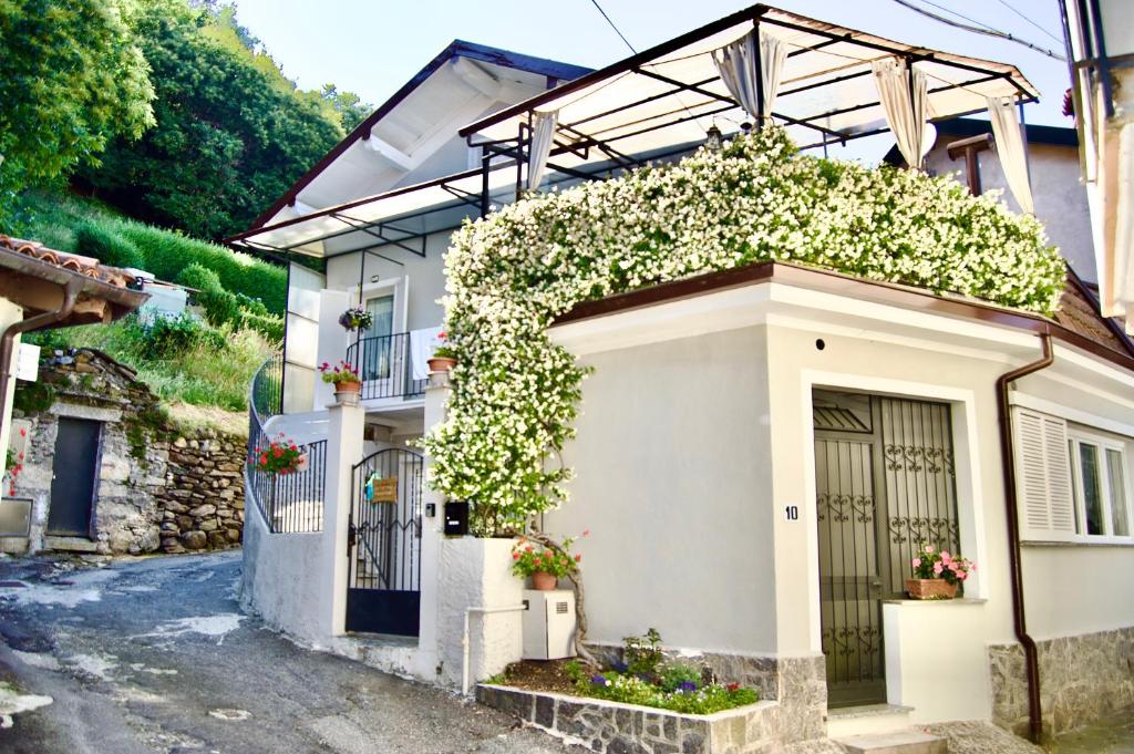 una casa bianca con dei fiori sul lato di Casa della Rosina a Stresa
