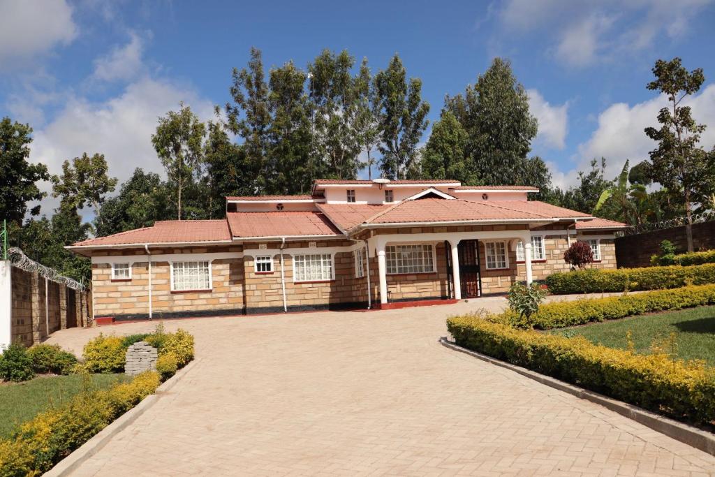 a house with a red roof and a driveway at The Meru Manor in Meru