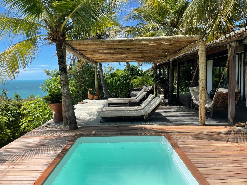 a house with a swimming pool on a wooden deck at Casa Mandakarú in Icapuí