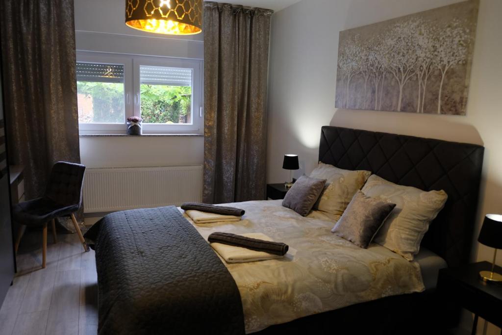 a bedroom with a bed with two remote controls on it at Apartman Gold in Požega