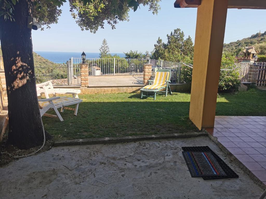 un patio con tavolo, panca e oceano di Villa Ginevra a Costa Rei