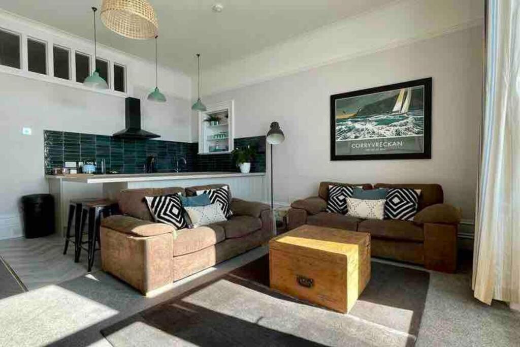 een woonkamer met 2 banken en een bar bij Westbay Seafront Apartment in Oban